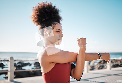 Image of Stretching, start and woman with music for running, exercise and cardio in California. Ready, warm up and runner girl thinking of a workout with audio for motivation while training by the sea