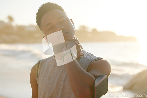 Image of Neck pain, fitness and black man at beach running, exercise or training technology, music and morning goals. Stretching muscle. health and sports runner, athlete or person by ocean for cardio workout