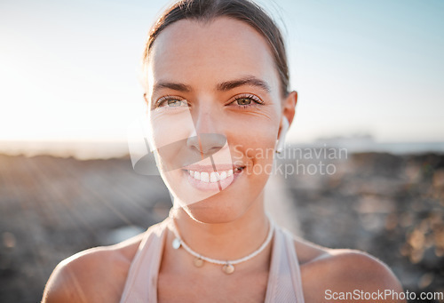 Image of Portrait, fitness and music with a sports woman outdoor, standing against a mockup sky background. Face, exercise and wellness with a female athlete cardio or endurance training alone outside