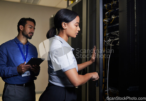 Image of Server room, engineer teamwork and woman opening panel for maintenance or repairs at night. Cybersecurity, programmers and female with man holding tablet for software or networking in data center.