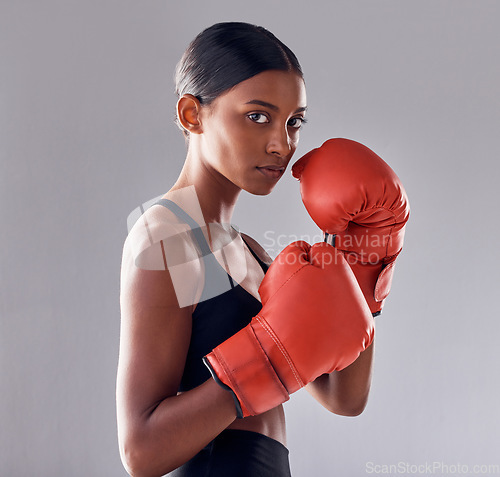 Image of Boxing, gloves and portrait of woman in studio for sports exercise, strong muscle or mma training. Indian female boxer, workout and fist fight for impact, energy and warrior power in battle challenge