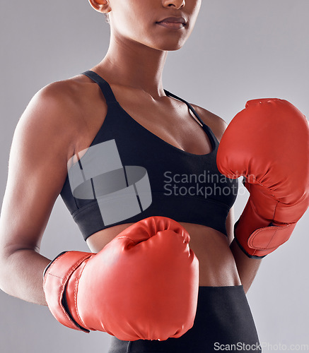 Image of Boxing, fitness gloves and woman in studio for sports exercise, strong muscle or mma training. Female boxer, workout and fist fight for impact, energy and warrior power in battle, challenge or action