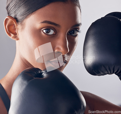 Image of Boxing, gloves and portrait face of woman in studio for exercise, strong focus or mma training. Female boxer, workout and fist fight for impact, energy and warrior power in battle, fitness and action