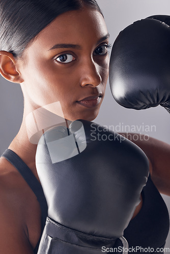 Image of Boxing hands, gloves and portrait of woman in studio for sports, strong muscle or mma exercise. Female boxer, workout and fist fight of warrior, energy or fitness power in battle, challenge or action