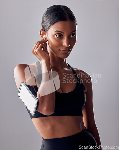 Image of Fitness, music and woman in studio for exercise, wellness and advertising on grey background space. Workout, mockup and girl relax with podcast, audio for track for motivation while training isolated