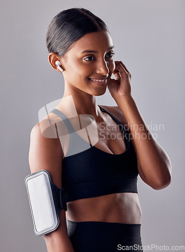 Image of Studio, fitness and woman with music in exercise, wellness or advertising on grey background space. Workout, mockup and girl relax with podcast, audio or track for motivation while training isolated