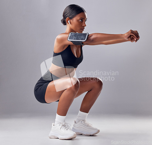 Image of Black woman, studio background and squat training for fitness, smartphone and strong legs, muscle or mind. Gen z girl, personal trainer and phone with vision, motivation or mindset for anatomy goal