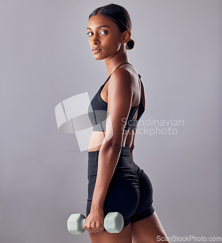 Image of Woman, focus portrait and dumbbell in studio for strong body, wellness power or healthy workout goals. Indian female, bodybuilder and weights of fitness, training and muscle energy in sports exercise