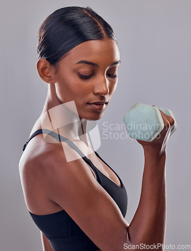 Image of Woman, bicep and dumbbell training in studio for strong body, action and wellness goals. Indian female, bodybuilder and weights of fitness, power exercise and muscle energy for healthy sports workout