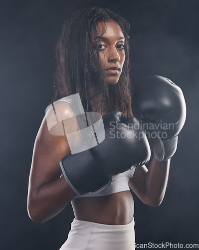 Image of Boxer gloves, woman and portrait on black background for sports, strong focus or mma training. Female boxing, champion and fist fight in studio, impact and warrior energy for power of fitness workout