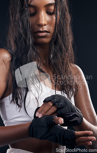 Image of Boxer, gloves and sweat with a sports woman getting ready in studio on a black background for fitness. Exercise, health and training with a female boxing athlete sweating during a combat workout