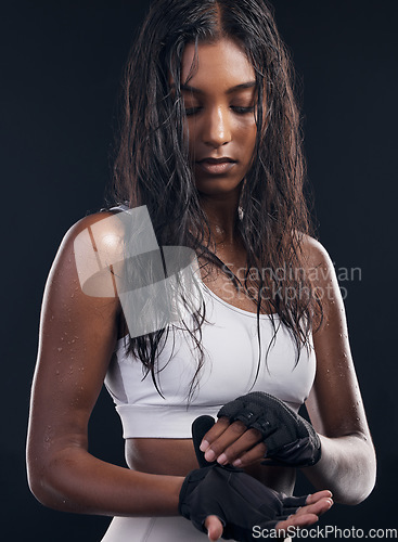 Image of Boxing, gloves and sweat with a sports woman getting ready in studio on a black background for fitness. Exercise, health and training with a female athlete or boxer sweating during a combat workout