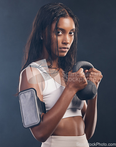 Image of Woman, kettlebell and portrait of exercise in studio for fitness, sports workout or serious mindset. Face of strong female, bodybuilder and weights for training with armband, energy and on background