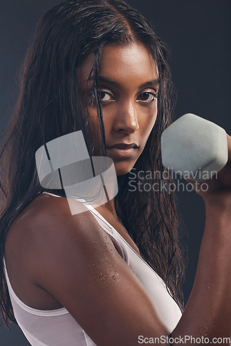 Image of Woman, portrait and exercise with dumbbell on black background, strong body and focus mindset. Indian female, bodybuilder and studio weights for fitness, power training and energy for sports workout