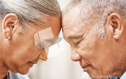 Image of Face, love and support with a senior couple in their home, touching heads in trust or solidarity together. Relax, peace or romance with a mature man and woman bonding in their house during retirement