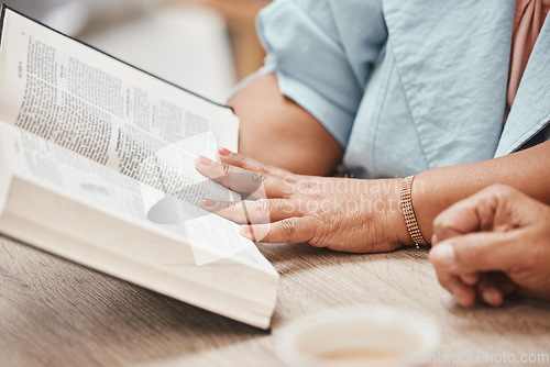 Image of Hands, bible and reading with a senior couple studying a book together in their home during retirement. Jesus, faith or belief with a man and woman praying to god in their house for spiritual bonding