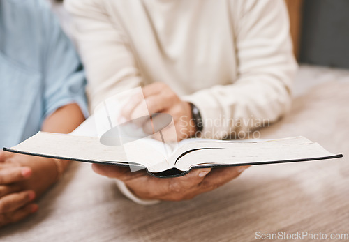 Image of Hands, bible and prayer with a senior couple reading a book together in their home during retirement. Jesus, faith or belief with a man and woman praying to god in their house for spiritual bonding