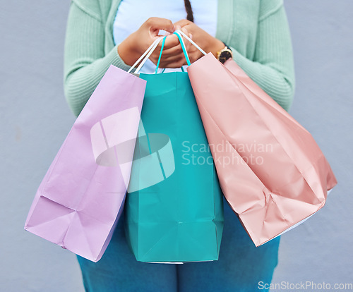 Image of Fashion, hands or black woman with shopping bag or gift on promotion in retail therapy against wall. Freedom, relaxing or girl on holiday vacation with clothes or products on discounted sales offer