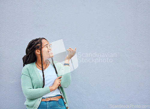 Image of Mockup, hands and black woman pointing to space for advertising, empty and grey wall background. Hand, gesture and girl relax, happy and smile in studio for product placement, branding and copy space