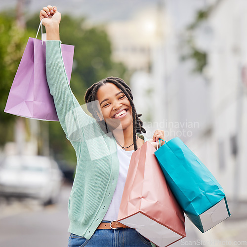 Image of Fashion, portrait or black woman with success, shopping bag or smile walking in celebration on city street. Happy, relax or excited gen z girl with clothes, gift or products on discounted sales offer