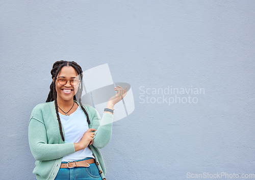 Image of Mockup, portrait and black woman pointing to space for advertising, empty or grey wall background. Face, gesture and girl relax, happy and smile in studio on product placement, isolated or copy space