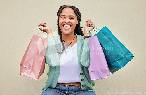 Image of Fashion, portrait or happy African girl with shopping bag or smile in retail therapy with wall background. Freedom, relax or excited black woman with clothes or products on discounted sales offer