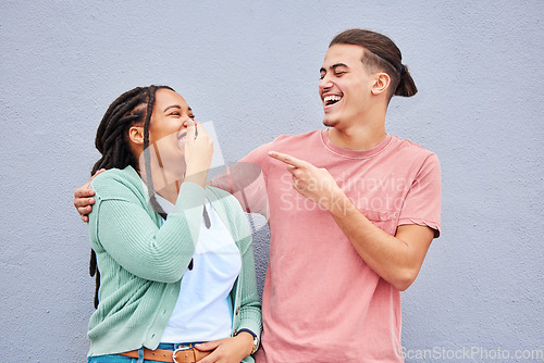 Image of Joking, laughing and happy with a couple on a gray background, outdoor for fun or freedom together. Laughter, humor or smile with a young man and woman enjoying laughter while bonding against a wall