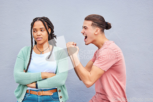 Image of Winner, competition and success with a man celebrating after winning a bet against his loser girlfriend on gray background. Success, wow or victory with a boyfriend cheering a win against a woman