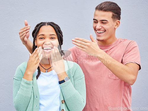 Image of Wow, surprise or love and a couple on a gray background outdoor with a man covering the eyes of his girlfriend. Diversity, hands or dating with a woman being surprised by her boyfriend against a wall