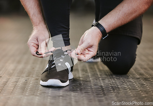 Image of Fitness, hands and tie shoes in gym to start workout, training or exercise for wellness. Sports, athlete and man tying sneakers or footwear laces to get ready for exercising or running for health.