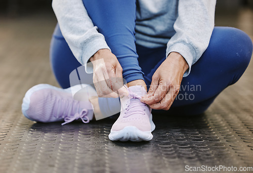 Image of Hands, fitness and tie shoes in gym to start workout, training or exercise for wellness. Sports, athlete health or senior woman tying sneakers or footwear laces to get ready for exercising or running