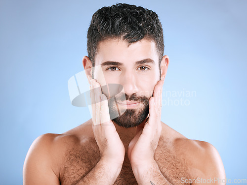 Image of Skincare, face and portrait of man with hand on beard, morning cleaning treatment isolated on blue background. Facial hygiene, male model and grooming hair health, wellness and skin care in studio.