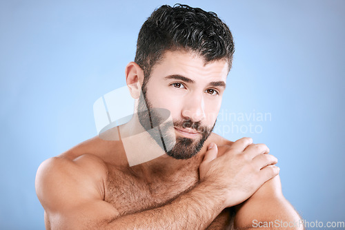 Image of Skincare, portrait and man relax in studio for grooming, hygiene and cosmetics on blue background. Face, beauty and guy skin model satisfied with luxury, pamper and treatment, body care and isolated