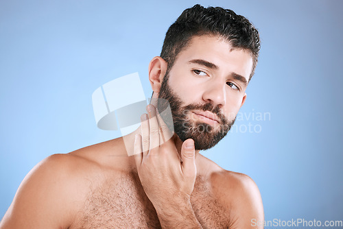 Image of Idea, skincare and grooming with a man model in studio on a blue background for natural wellness or beauty. Face, beard and skin with a handsome young male thinking about cosmetics or treatment