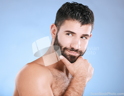 Image of Idea, beauty and wellness with a man model in studio on a blue background for natural skincare or grooming. Face, beard and skin with a handsome young male thinking about cosmetics or treatment