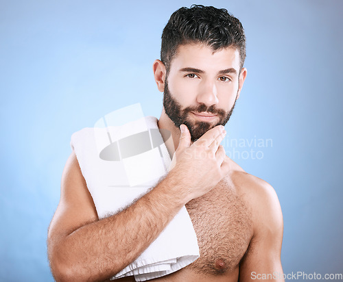 Image of Portrait, skincare and man with towel, cleaning and hygiene on blue studio background. Face detox, male and gentleman washing, dermatology and morning routine for grooming, treatment and smooth skin