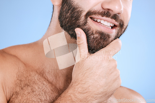 Image of Skincare, beard and man with smile closeup in studio for grooming, hygiene and face cosmetic on blue background. Facial hair, male and model relax in luxury, beauty and routine, treatment or isolated