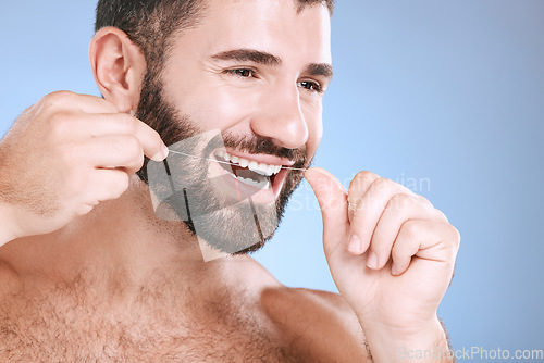 Image of Dental, product or floss with a man in studio on a blue background with teeth hygiene for healthy gums. Dentist, healthcare and mouth with a young male oral cleaning to remove plague or gingivitis