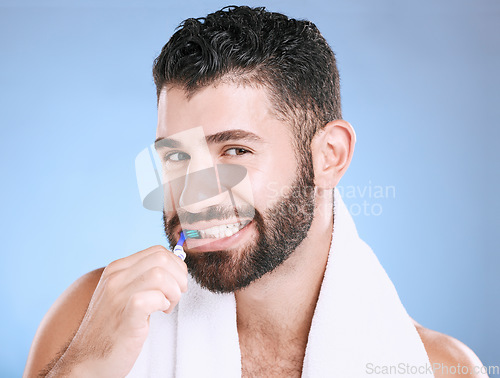 Image of Studio portrait, man and toothbrush for teeth, dental wellness and healthy smile, mouth and cleaning. Happy male model, oral care and fresh breath for gums, dentistry and hygiene on blue background