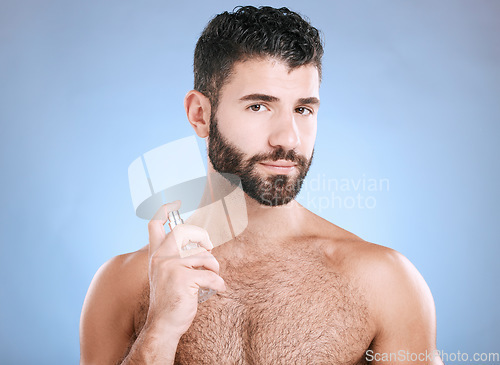 Image of Man portrait, fragrance and skincare bottle product of aftershave, face wellness and luxury cosmetics in studio. Male model, beauty and spraying perfume, parfum and body cologne on blue background