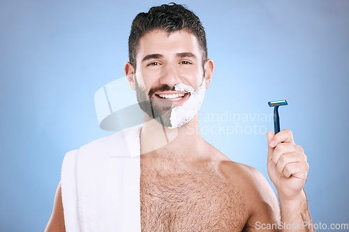 Image of Portrait of happy man with foam on beard, razor and towel in skin product placement in studio mock up. Shaving cream on face, smile and hair or skincare for male model, isolated on blue background.