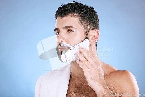 Image of Facial, man putting foam on beard with hand on face, towel and product placement in studio mock up. Shaving cream, hair and skincare for male model grooming, isolated on blue background with space.