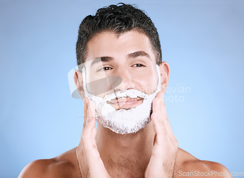 Image of Shaving, foam on beard and man with hands on face, smile and product placement in studio mock up. Shave cream facial, hair and skincare for happy male model grooming, isolated on blue background.