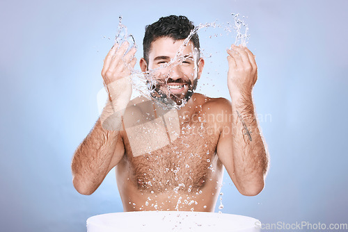 Image of Water splash, skin care and portrait of man for clean spa facial for beauty hygiene and dermatology. Aesthetic model person washing face on blue background for cosmetics, body and detox cleaning