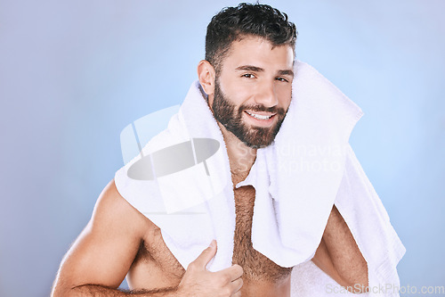 Image of Man after shower with hygiene, towel and beauty in portrait, smile, face and grooming in studio. Skincare, cosmetics and cleaning body with healthy skin, mockup and cosmetic care on blue background