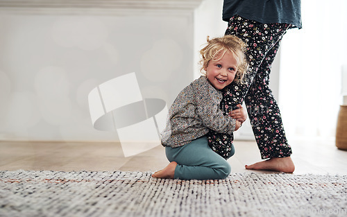 Image of Happy, child clinging to leg of woman and playful fun and smile on carpet in home with mother. Little girl playing, laughing and joking with happiness, mom in pajamas and trust on floor in apartment.