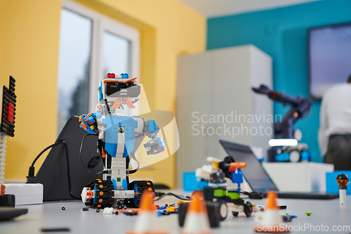 Image of A student testing his new invention of a robotic arm in the laboratory, showcasing the culmination of his research and technological prowess.