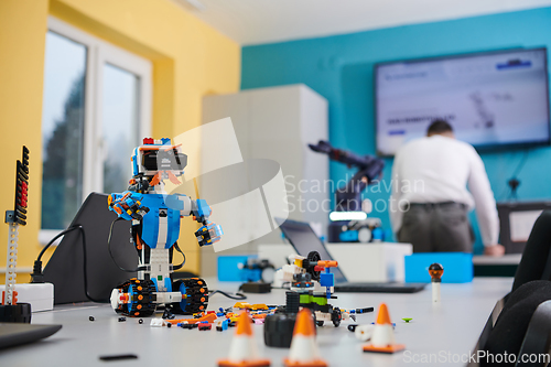 Image of A student testing his new invention of a robotic arm in the laboratory, showcasing the culmination of his research and technological prowess.