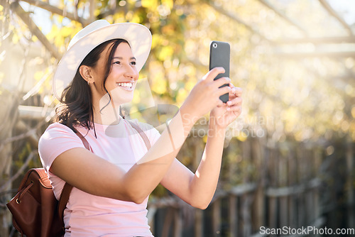 Image of Phone, nature and woman taking a picture while on an outdoor holiday or weekend trip. Travel, freedom and happy young lady with a smile taking a photo of view on cellphone while on adventure vacation