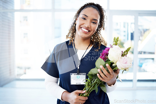 Image of Success, celebration and portrait of doctor with flowers at a hospital for promotion and gift for work. Care, happy and female nurse with bouquet as a present for commitment in healthcare nursing job